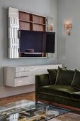 Glass coffee table, sofa and open wall-mounted TV cabinet above white floating sideboard