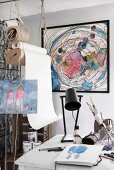 Artist's studio with framed pastel artwork on wall