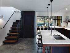 Theke mit Marmorarbeitsplatte in offener Küche mit Treppe