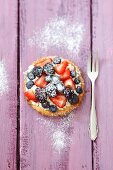 A tartlet with whipped cream and fresh berries