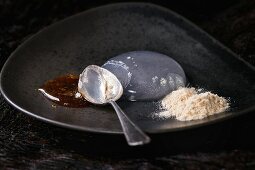 Raindrop Cake mit Karamellsauce und gebratenen Mehl auf Keramikteller