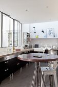Black fitted kitchen with interior windows in loft apartment