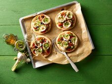 Mini pizzas with rocket, tomatoes and goat's cheese