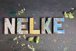 The word 'Nelke' (carnation) made from vintage alphabetic printing blocks
