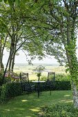 Seating area in idyllic summer garden with view of landscape