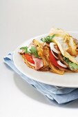 Pancakes with beefsteak, tomatoes, onion and rocket