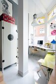 Desk below window and white filing cabinet in study