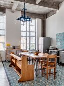 Ornate tiles and eclectic furnishings in open-plan kitchen with tall industrial windows