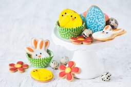 Colourful Easter biscuits and quails egg's on a cake stand