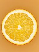 A slice of orange on orange surface, close-up