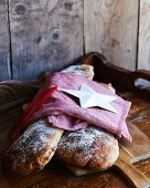 Two light rye breads under a tea towel and a Christmas decoration