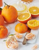 Orangen, eine Hälfte ausgepresst, und Saftpresse aus Glas