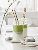 A green smoothie with avocado and matcha poured over yoghurt in a glass