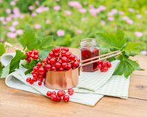 Rote Johannisbeeren im Kupfertopf auf Gartentisch