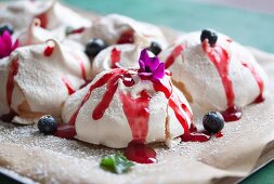 Classic meringues with blueberries and raspberry sauce