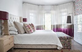 Bed with button-tufted headboard and sides in elegant bedroom