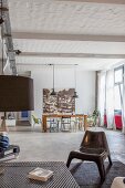 Lounge area and dining table with various chairs in front of large vintage-style photo