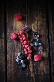 Frozen redcurrants, blackcurrants, raspberries and blackberries on a wooden surface