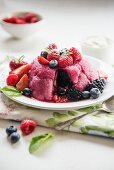 Summer pudding on a plate with fresh berries, sliced