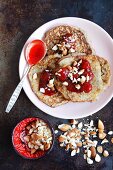 Flourless banana and couscous pancakes with strawberry jam and almonds