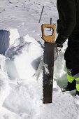 Bausteine aus Schnee werden ausgesägt