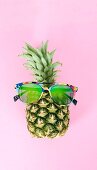 A pineapple wearing colourful sunglasses