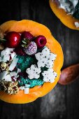 Melon bowl with muesli, coconut yogurt, chia spirulina pudding, dragon fruit flowers and berries