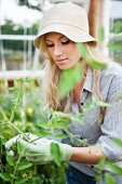 Junge Frau mit Hut bei der Gartenarbeit