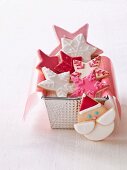 Star shaped Christmas biscuits in a loaf tin next to a Father Christmas biscuit