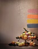 Citrus fruits on cake stand and paint samples on wall; photographic art