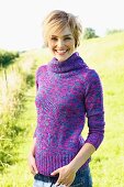 Young, blonde woman wearing colourful roll-neck jumper