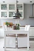 White dining table and chairs with loose covers in kitchen