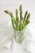 Green asparagus sticks in a plastic cup