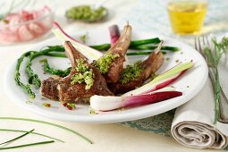 Lamb chops stuffed with pink peppercorns and pesto, served with asparagus and spring onions