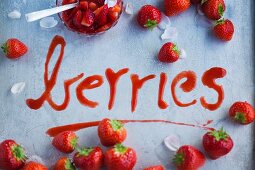 The word 'berries' written out in strawberry sauce