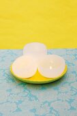 DIY bowl-shaped candles on yellow plate against yellow background