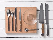 Assorted kitchen utensils: cutlery, kitchen knives and a glass bowl