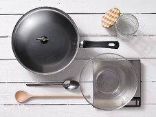 Assorted kitchen utensils:a frying pan, spoons, a preserving jar and scales