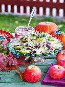 Birnen-Rotkohlsalat mit Mandeln auf herbstlichem Tisch im Freien