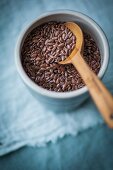 Flax seeds with a wooden spoon in a small bowl