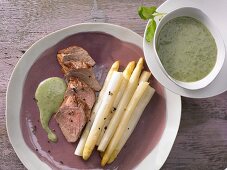 Oven-baked asparagus with pork fillet and basil sauce