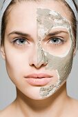 Junge Frau mit Gesichtsmaske auf einer Gesichtshälfte