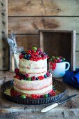 A two-tiered semi-naked cake with fresh berries