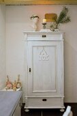 Christmas decorations on white-painted vintage-style wooden cupboard