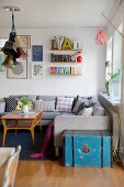 Grey couch and String shelves in cosy living room with retro ambiance