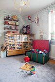 Sortiertes Spielzeug in Retro Schrank mit durchsichtigen Schubladen in Jungenzimmer