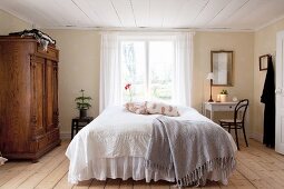 Schlafzimmer im Landhausstil mit niedriger Decke und Holzboden