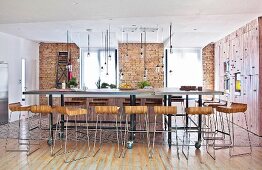 Designer-Barhocker vor langem Esstisch auf Rädern in offenem Wohnraum