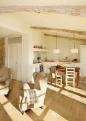 Terracotta floor and wood-beamed ceiling in open-plan interior in natural shades