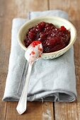 Cranberry jam in a bowl with a spoon